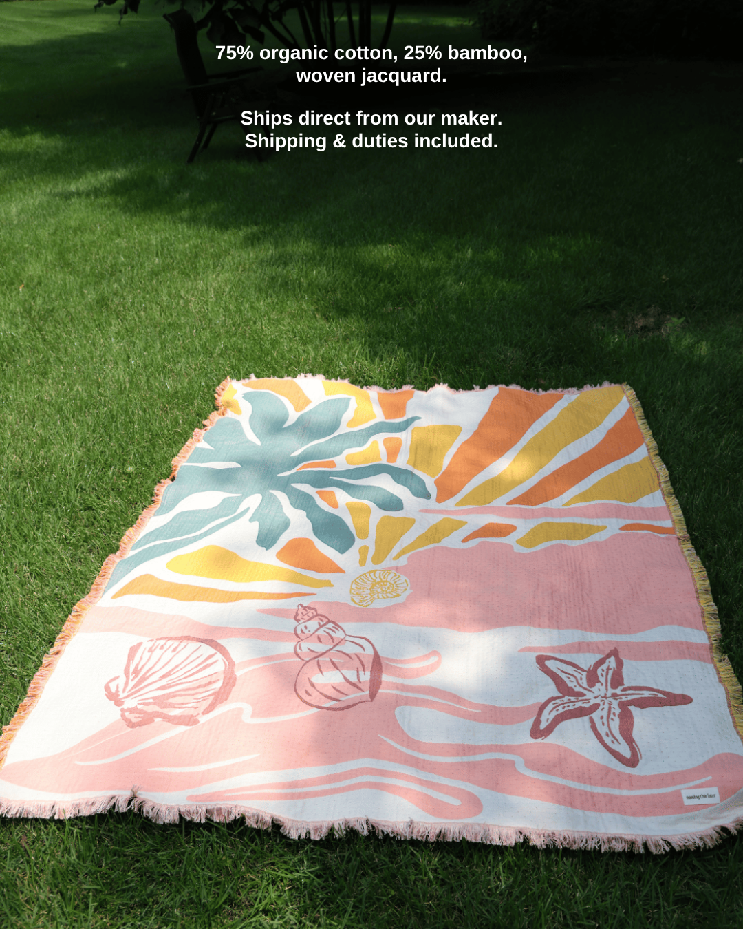 Aeraloom throw in Coral Coast on the grass – 75% organic cotton, 25% bamboo, woven jacquard; ships direct from our maker, shipping & duties included