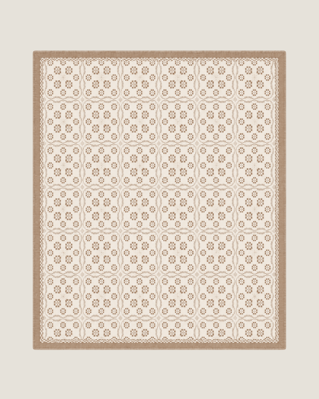 Terra Versatile Quilt in Sandstone, a neutral organic cotton quilt used as the base layer on a bed